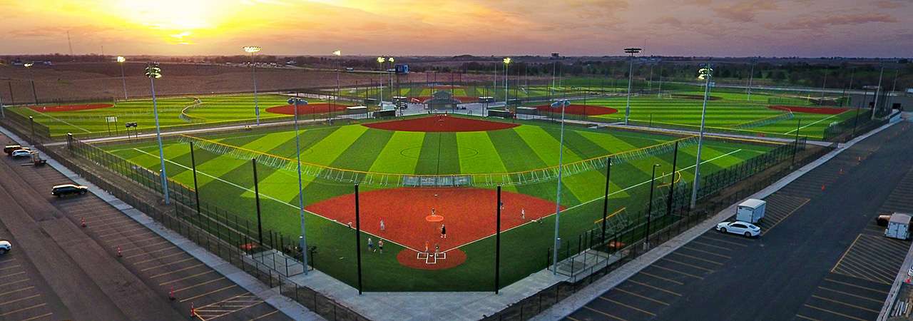 Baseball diamond with sun setting in distance.
