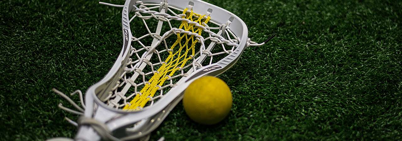 Lacrosse stick and ball laying on field