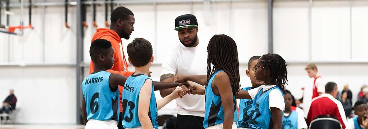 Youth team and coaches fist bumping.