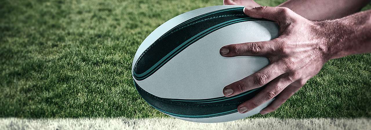 Close up of hands holding rugby ball