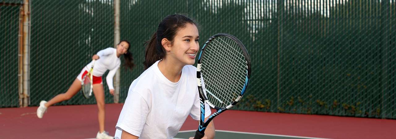 Younger girls playing tennis